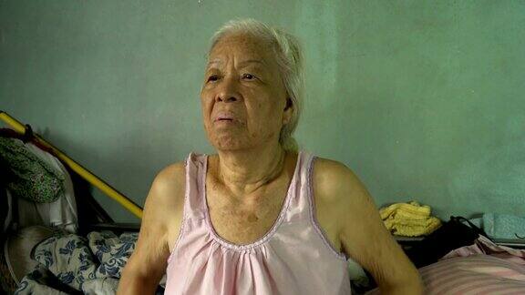 年老的亚洲退休妇女在床上做一些运动