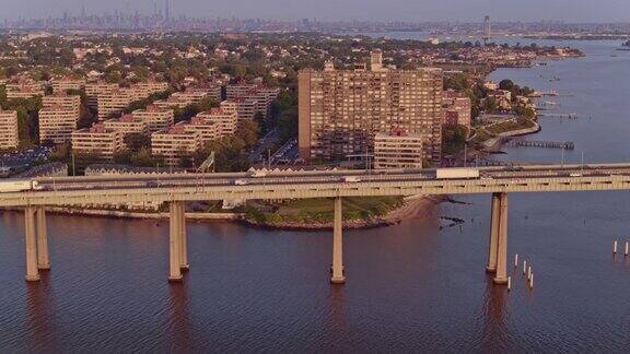 鸟瞰图的比彻斯特住宅区在皇后区与曼哈顿在Throgs颈桥在日出的遥远的背景无人机视频片段与向前摄像机运动