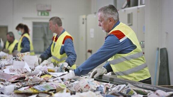 回收设备工人用手分类废纸