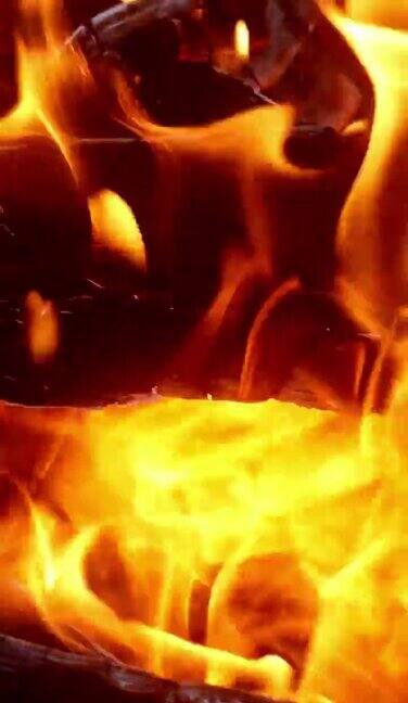 明亮的火和火焰燃烧在炎热的壁炉篝火或烧烤美丽的火舌和灼热的煤炭辉光