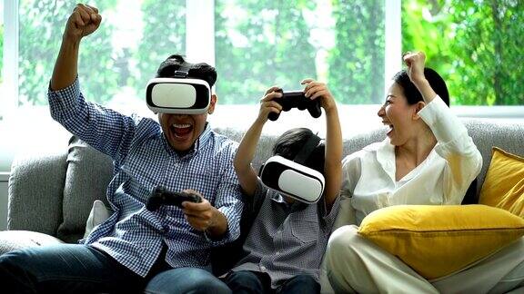 在客厅里使用虚拟现实模拟器眼镜赢得游戏后微笑的家庭举手