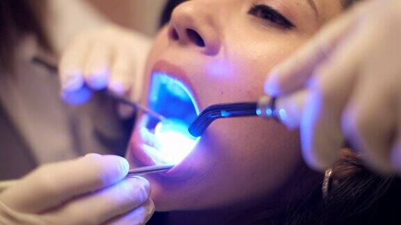 牙医用紫外线照射病人的牙齿
