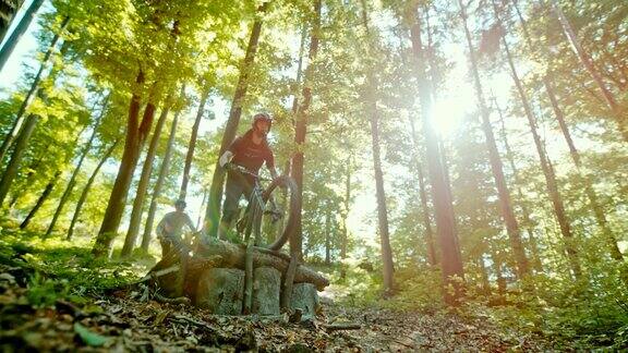 超级SLOMOMTB摩托车手跳过一个木斜坡在阳光明媚的森林