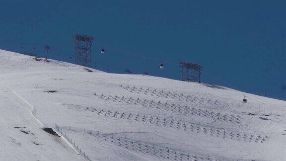 在被雪覆盖的山坡上攀爬的缆车安装了防止雪崩的系统
