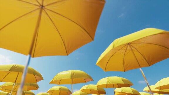 低视角拍摄黄色的沙滩伞衬着晴朗的蓝天