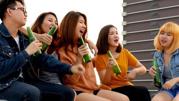 一群亚洲年轻人在屋顶上开啤酒瓶派对
