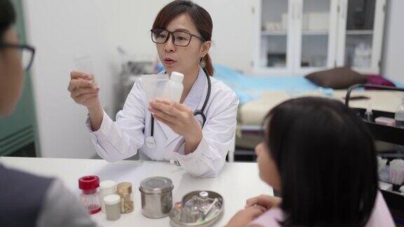 亚洲华人女医生开药并向病人的父亲解释