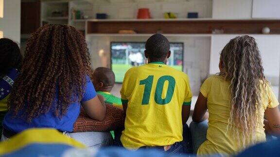 朋友们在家里观看足球比赛时庆祝进球