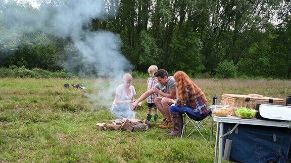 一家人在自然公园里用篝火烤食物
