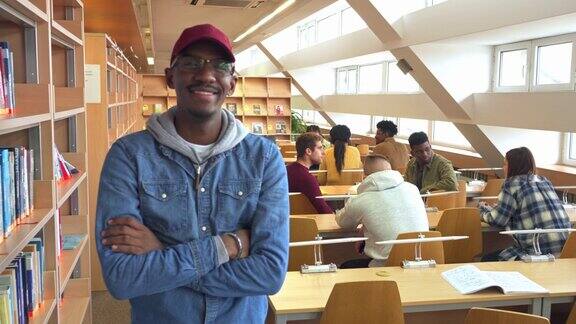 一个轻松快乐的学生站在大学图书馆里
