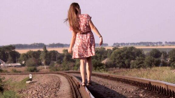 年轻女孩在铁轨上行走