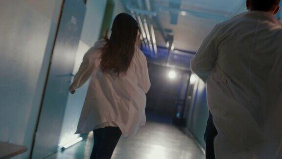 两个急诊医生在医院走廊上跑着有应急灯照明