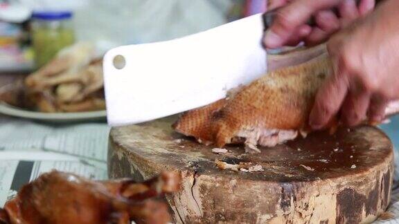 用大刀在木板上切鸭肉