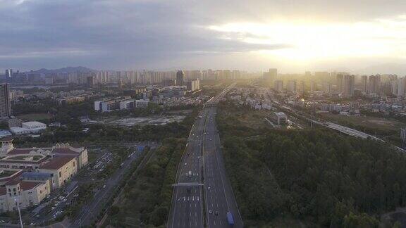 高速公路的车流和夕阳下城市建筑的航拍视频