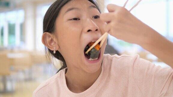 亚洲女孩在美食广场吃寿司生活理念