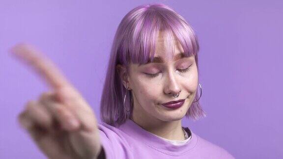 肖像严肃时髦的女人显示拒绝手势停止手指手势女孩被孤立在紫色的背景上