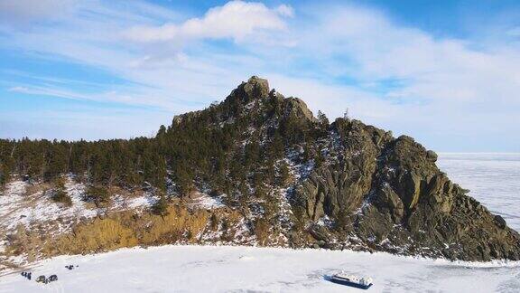 山脉、岩石和丘陵环绕着冰冻的湖泊寒冷晴朗的冬日