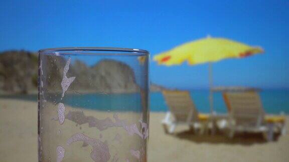 阳光明媚的海滩上空荡荡的啤酒杯