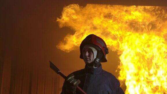 慢镜头消防队员站在镜头前火焰作为背景