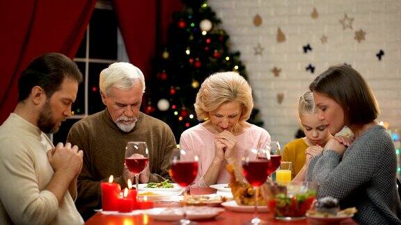 传统的家庭在圣诞餐前祈祷信仰上帝基督教