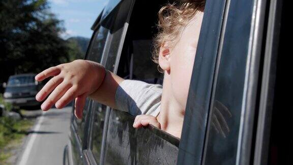 快乐可爱的小女孩微笑着从车窗里探出头来迎风而行慢镜头V3