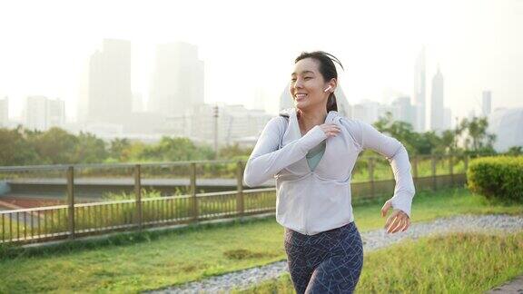 年轻的亚洲女子晨跑在城市慢镜头
