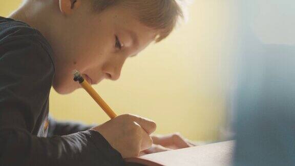 男孩(10-11)在书桌上做作业的特写