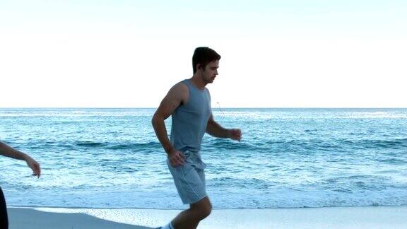 一对迷人的情侣在沙滩上跑步