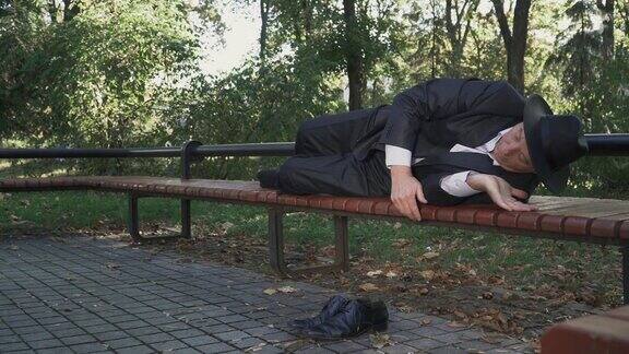 一个醉汉舒服地躺在公园的长椅上