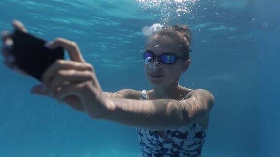 十几岁的女孩在游泳池里用智能手机自拍