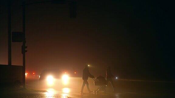 一家人推着婴儿车在停电时间过马路停电期间城市一片黑暗