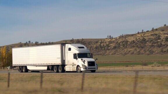 特写:白色半挂车拖着货物穿过美国乡村公路
