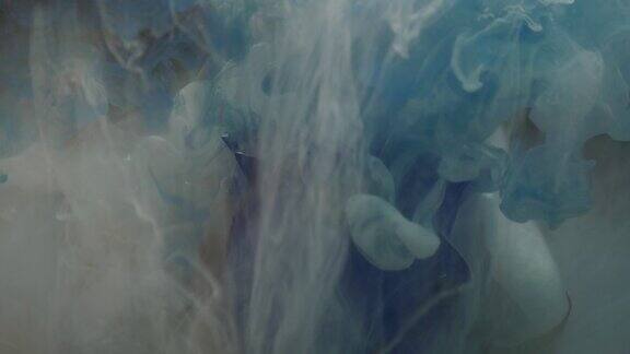 这是一张美丽的蓝色玫瑰和墨水在水中混合的照片