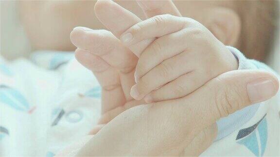 新生儿抱着母亲的手指的特写