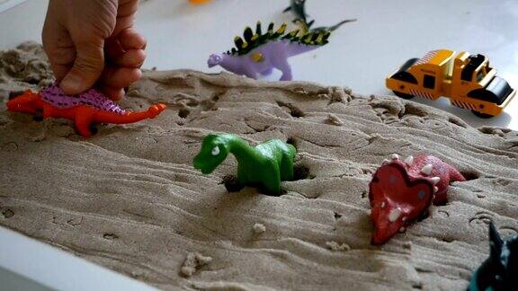 孩子们在动态的沙子上玩沙子和恐龙