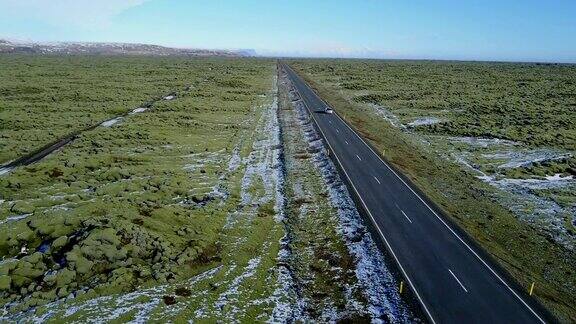 雪后的火山岩上飞过长路青苔田冰岛冬天的公路旅行