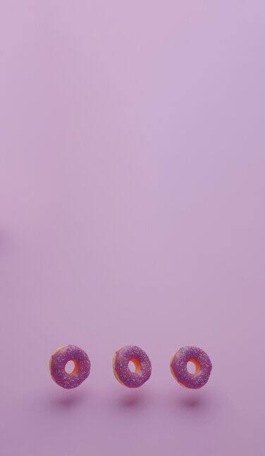 三个粉色的甜甜圈垂直漂浮在半空中