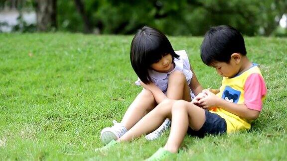 亚洲小男孩和小女孩在公园里吹肥皂泡