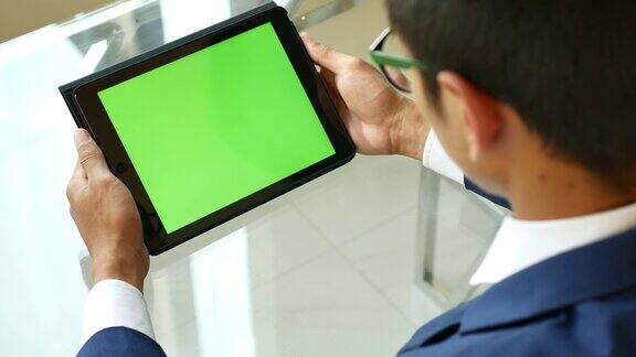过肩拍摄使用绿色屏幕的数字平板电脑色度键