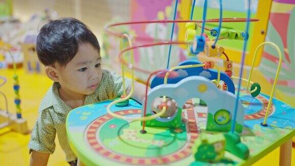 一个亚洲男孩在游乐园玩玩具