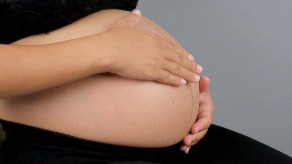 特写孕妇的肚子与她的手在上面