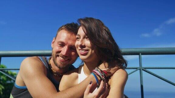 一对夫妇在露台上看海拥抱和快乐