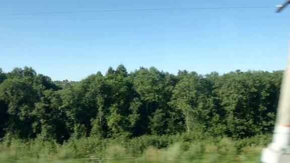 高速列车经过一片树林和一个村庄