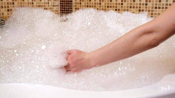 按摩浴缸里有很多泡沫一个女人的手碰到了泡沫