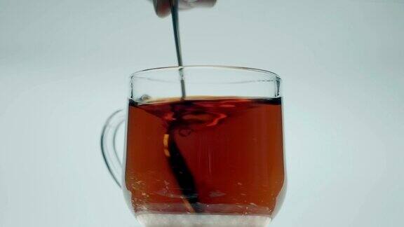 在玻璃杯中加入茶加入一匙红糖充分搅拌