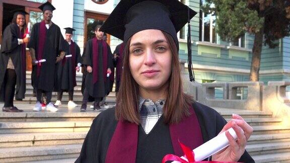 一名女学生手持文凭站在大学台阶上的肖像