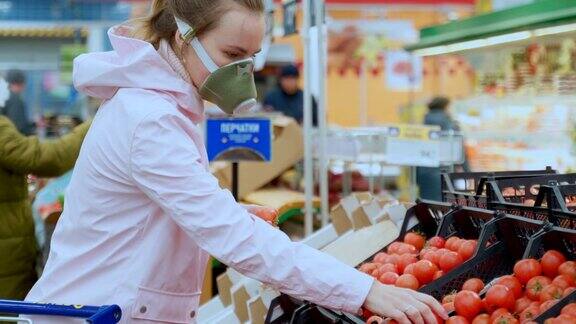 一名戴着防护口罩的妇女在超市仔细挑选蔬菜隔离新冠病毒安全措施