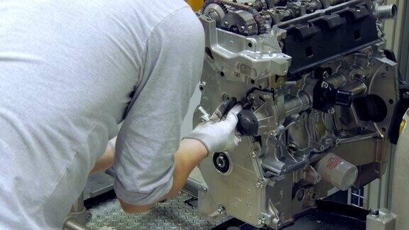 工人正在为汽车发动机安装螺栓现代汽车生产车间