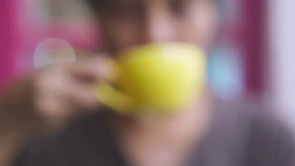 女人喝黄色杯子里的泡沫咖啡