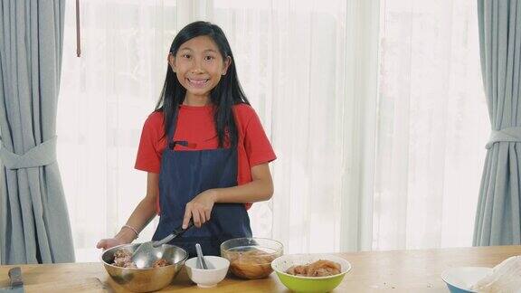 亚洲女孩在碗里用酱油腌制鸡肉慢镜头